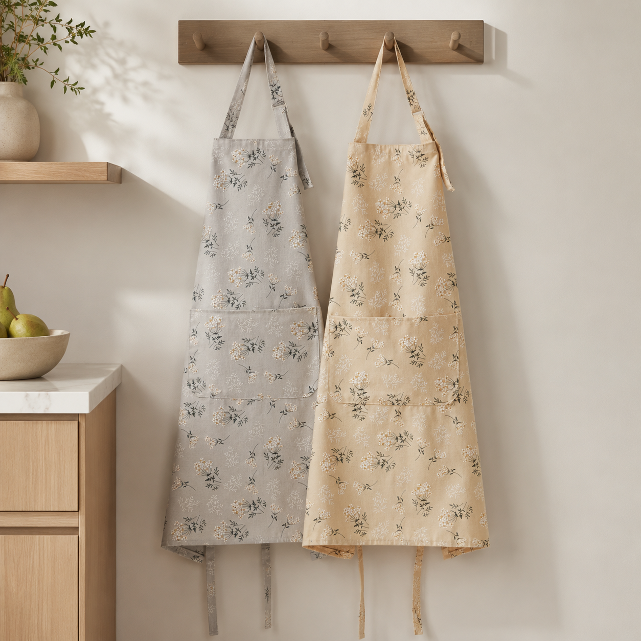 Mist gray and warm beige floral aprons hanging in a kitchen